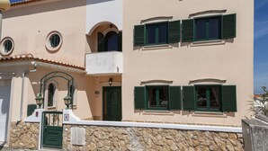 A two-story building with a stone facade, green shutters, and a balcony. - Serenidade do Mar & Spa (Peniche)
