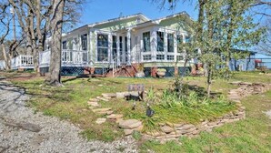 Ett stort hus i ett våningsplan med en veranda och en inhägnad trädgård.