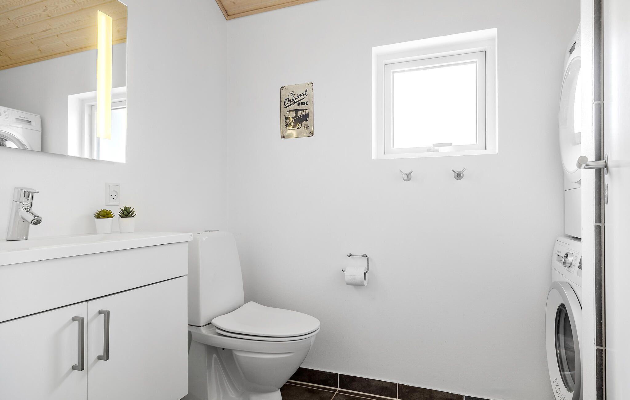 Un bagno moderno con WC, lavandino e lavatrice.