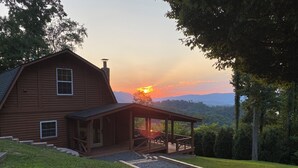 A wooden cabin with a porch and a view of the sunset over the mountains. - Stunning, Mtn-Top, Lakeview Cabin on Private 8 acres (Butler)