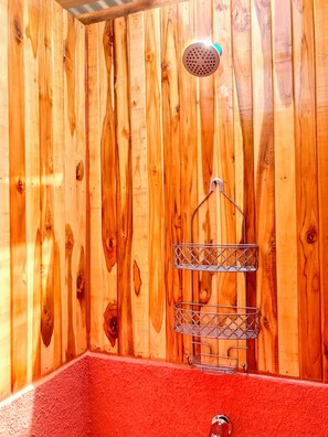 A wooden cabin with a red interior, a shower, and a metal shelf. - Magic place with ocean view & direct beach access - A wood house in paradise (Los Pargos)