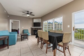 A living room with a sofa, chairs, a dining table, a TV, and a fireplace. - OceanSide Condo 3BR + 2Bath, Jacuzzi, Elevator - 5 (OCEAN CITY)