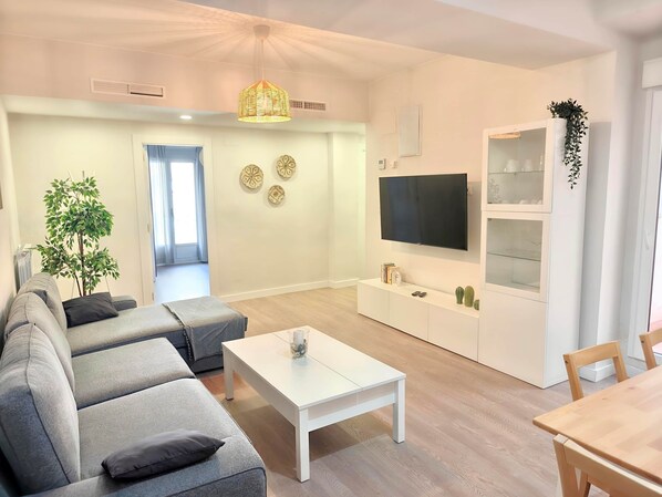 A modern living room with a sofa, a coffee table, a TV, and a cabinet.