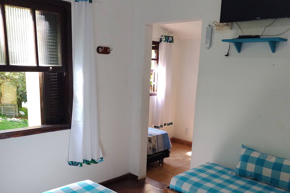 Een kamer met twee bedden, een televisie en een airconditioner.