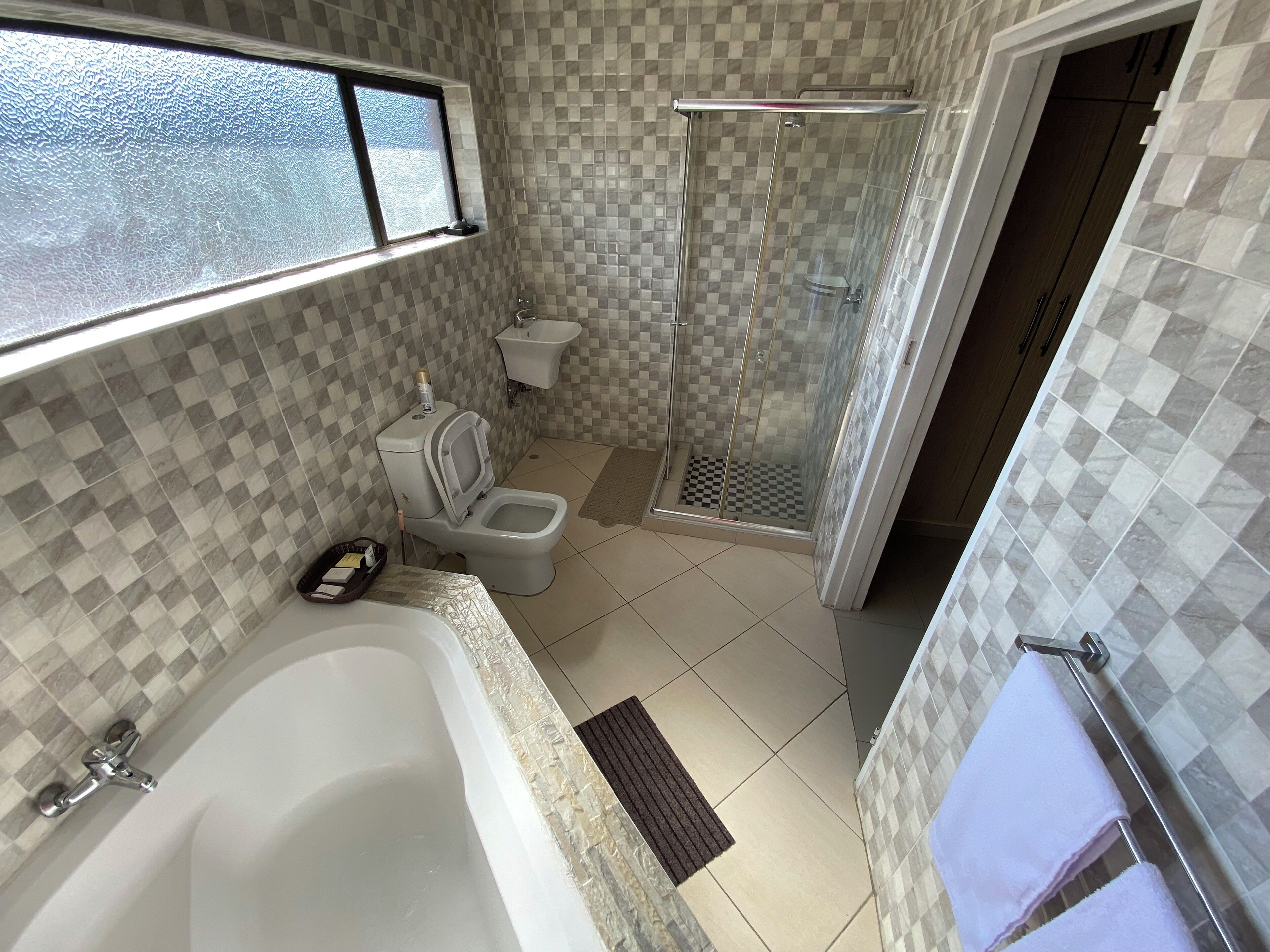 A bathroom with a bathtub, toilet, and shower.