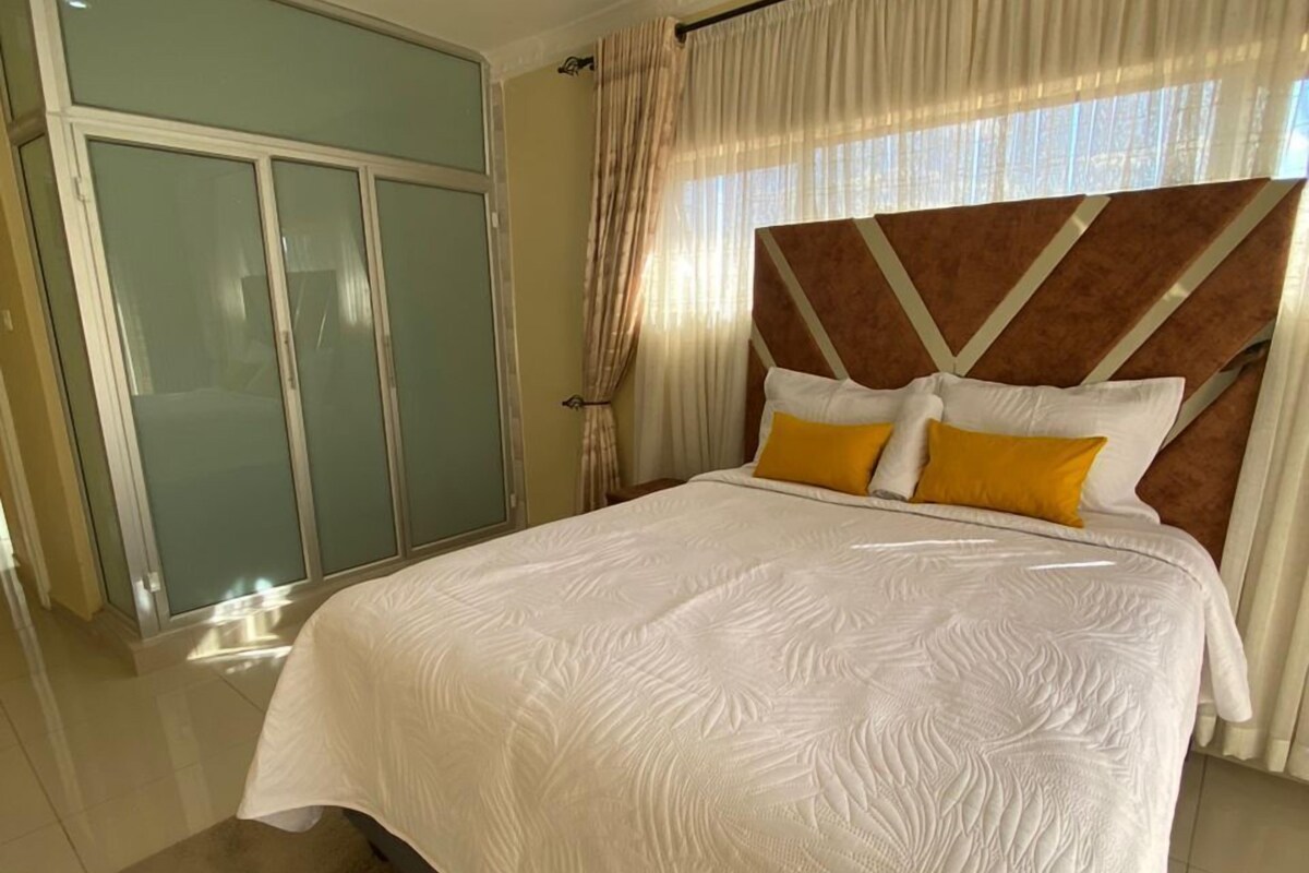 Een slaapkamer met een groot bed, een kledingkast en een badkamer.