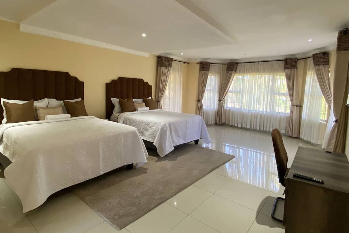 Een hotelkamer met twee bedden, een bureau en een stoel.