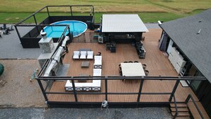 Een dakterras met zwembad, buitenmeubilair en uitzicht op het omliggende landschap.