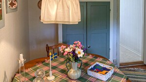 A dining table with a plaid tablecloth, a vase with flowers, a candle, and a small basket. - Beautiful home in Tranås with lake view (Tranås)