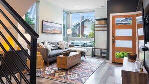 A modern living room with a sofa, coffee table, and a patterned rug.