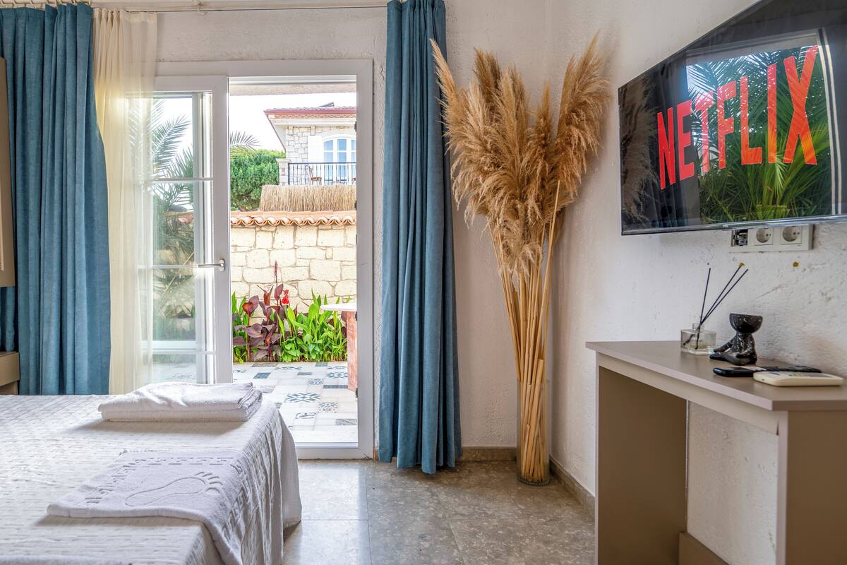 Une chambre d’hôtel avec un lit, un bureau, une télévision et une vue sur l’extérieur.