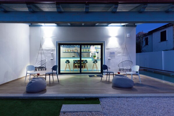 An outdoor patio with seating and a pool.