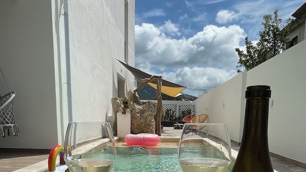 A poolside setting with a bottle of Akenta wine, two glasses, and a fruit platter. - Agua Dorada Retreat (Lula)