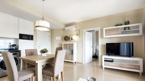 A modern kitchen with a microwave, coffee maker, and dining area with chairs and a table. - 1 bedroom beautiful apartment in Cabanes (Cabanes)