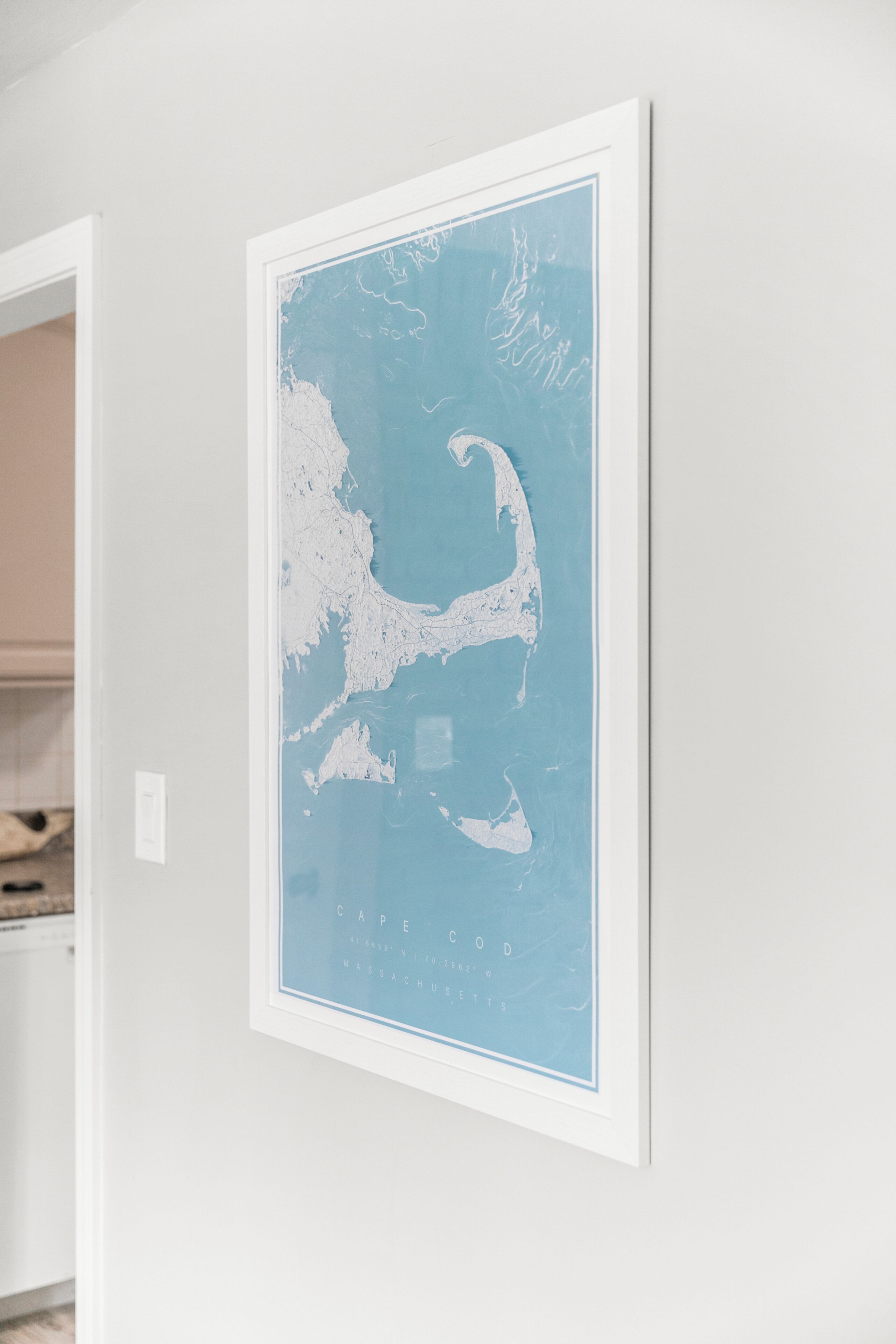Un mapa enmarcado de la región de Cape Cod sobre una pared blanca.