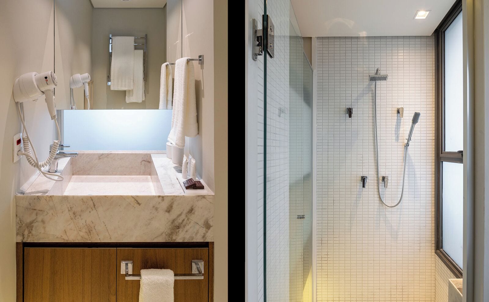 A modern bathroom with a marble sink, two hair dryers, a glass-enclosed shower, and a wooden cabinet.