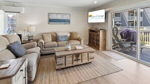 A living room with a sofa, coffee table, and a painting on the wall.