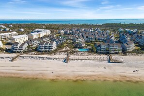 An aerial view of a coastal residential area with beachfront properties, a boardwalk, and a clear view of the ocean. - Direct Gulf Views· 16 Steps to Beach·All-King Beds (Port St. Joe)