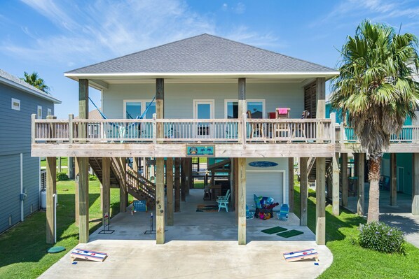 A two-story waterfront house with a balcony, wooden deck, and a small pool area. - Steps to Beach, Hot Tub, Gulf & Beach Views, Tiki Bar, Grill, Dogs, Games (Bolivar Peninsula)