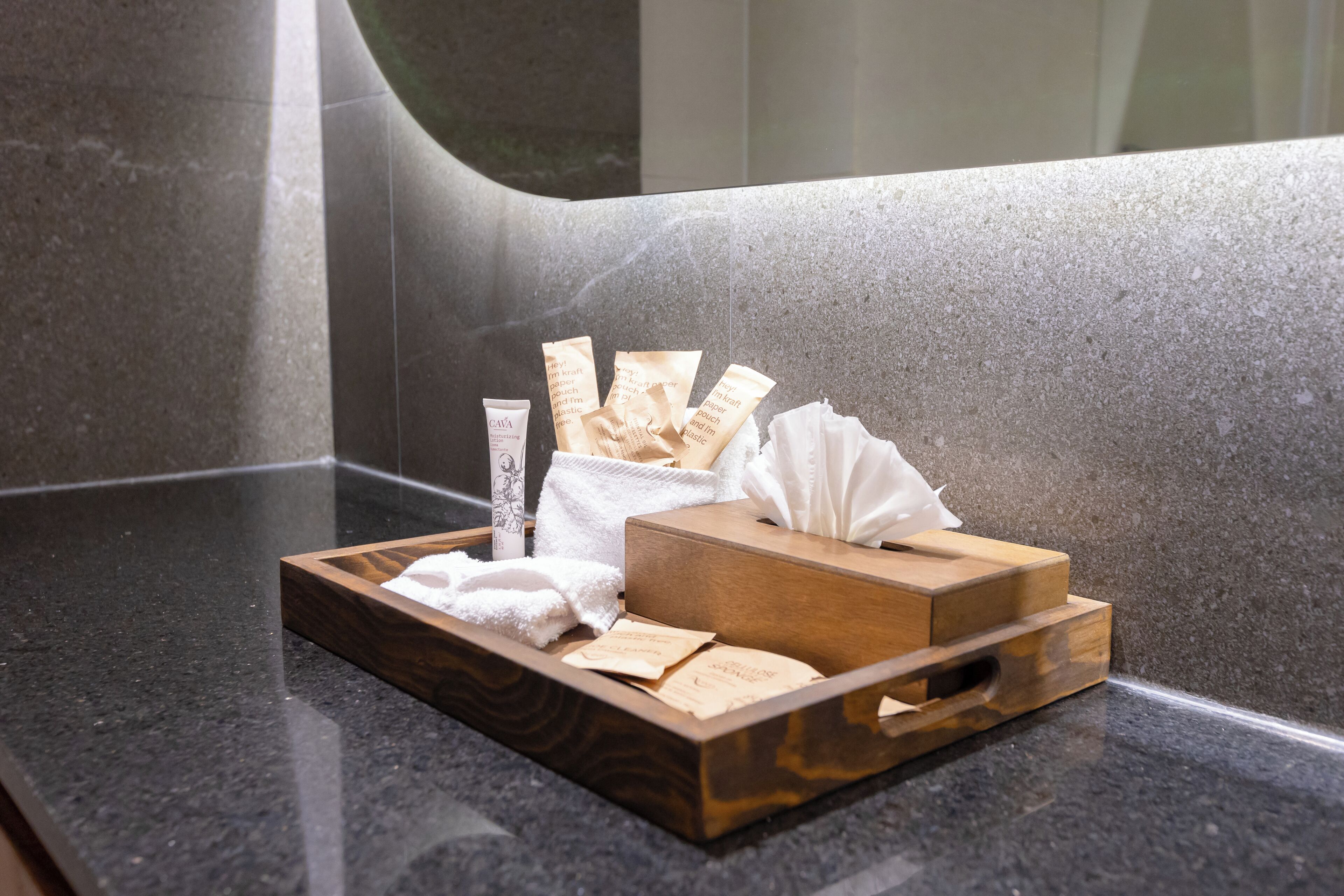 A tray with toiletries on a granite countertop in a bathroom.