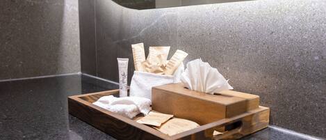 A tray with toiletries on a granite countertop in a bathroom.