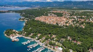 An aerial view of a coastal town with a marina, dense residential area, and surrounding mountains. - Awesome apartment in Omisalj (Omisalj)