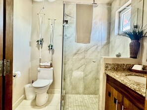 Un baño con inodoro, bidé y cabina de ducha.