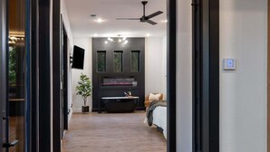 Een moderne badkamer met een vrijstaand bad, een grote spiegel en een plafondventilator.