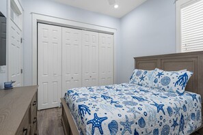 Une chambre à coucher avec un lit, une tête de lit en bois et une armoire blanche.