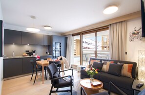 Relax in a stylish living area with a sofa set and dining table, offering a view of the surrounding landscape.