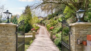 A stone pathway leading to a gated entrance with a lamp post on each side. - 5 Bed Lake House - Sleeps 10 - Nature Reserve (Devizes)