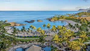 Un complexe hôtelier doté d’une piscine, d’une plage et offrant une vue sur l’océan.