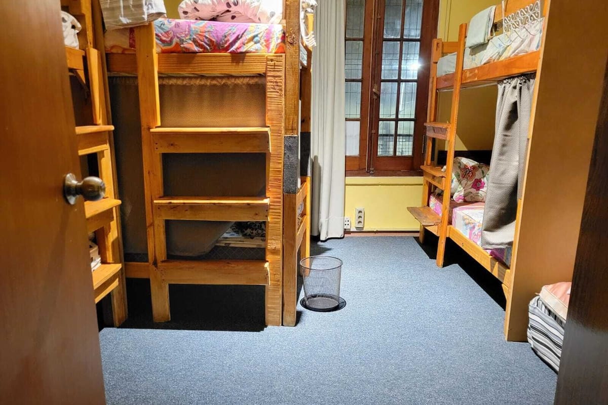 Um quarto pequeno com beliches e uma porta.