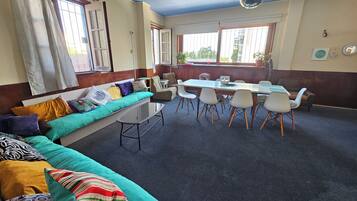 A room with a sofa, a dining table with chairs, and a disco ball.
