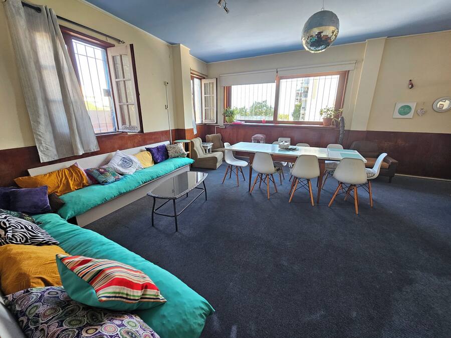 A room with a sofa, a dining table with chairs, and a disco ball.