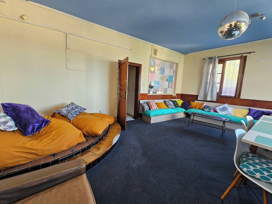 Una habitación con una cama curvada, un sofá, una mesita y una bola de discoteca.