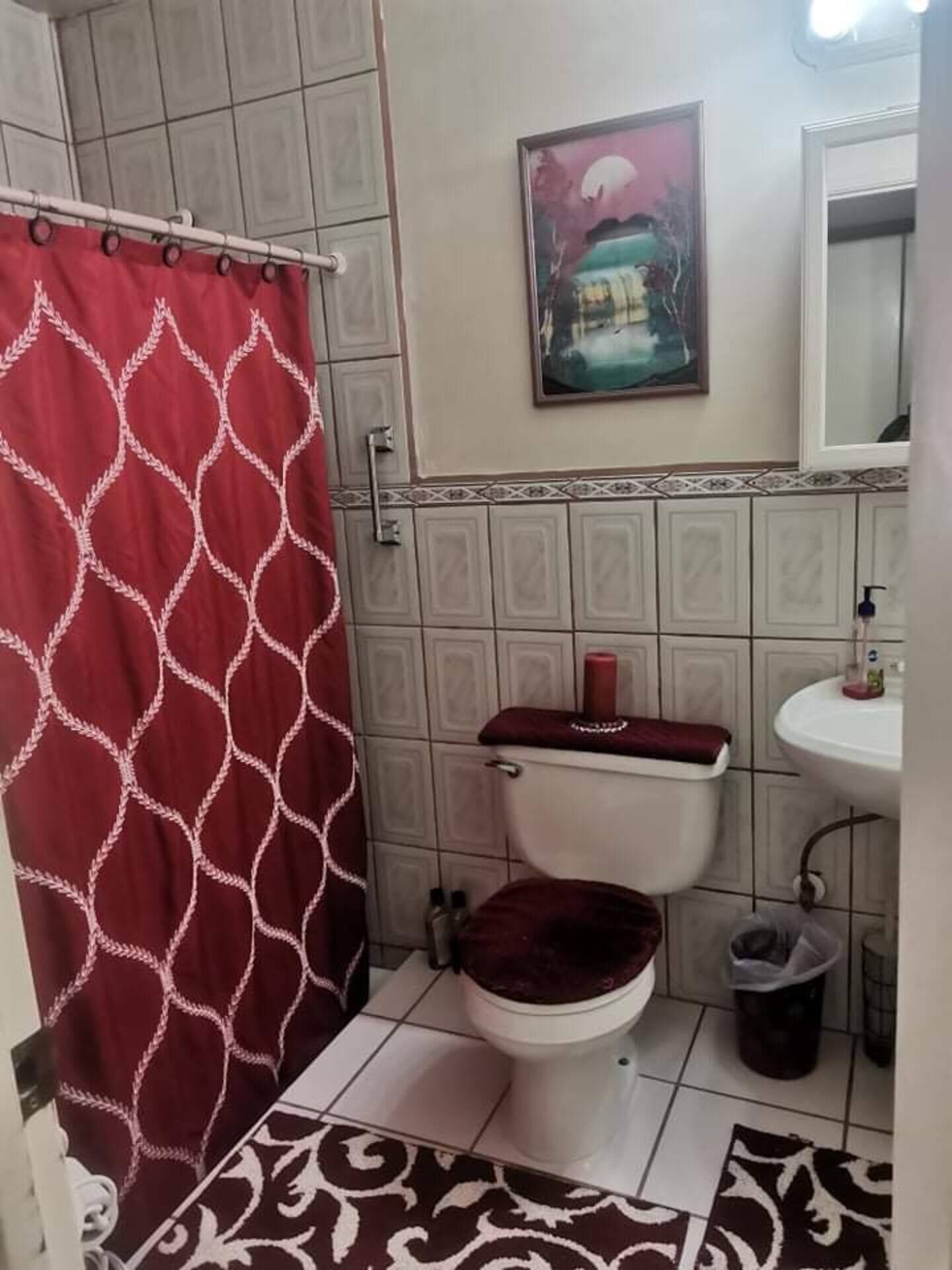 A bathroom with a toilet, sink, and shower curtain.