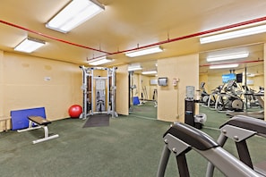 A gym with exercise equipment, a mirror, and a red exercise ball. - Tropical Kahana Hideaway with Ocean Views (Lahaina)