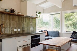 Enjoy meals with a view of the surrounding greenery from this kitchen's large window.
