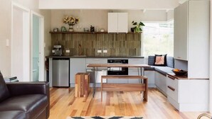 Una cocina moderna con comedor, suelo de madera y un banco empotrado.