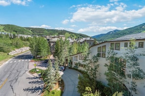 Un quartier résidentiel avec des maisons, une route et une chaîne de montagnes en arrière-plan.