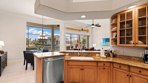 Una cucina moderna con piani in granito, mobili in legno e lavastoviglie integrata.