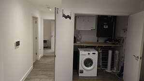 Une buanderie équipée d’un lave-linge, d’un sèche-linge et d’un ventilateur.