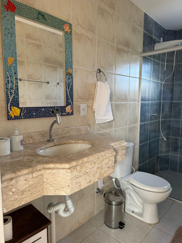 Une salle de bain avec deux lavabos, des toilettes et une douche.