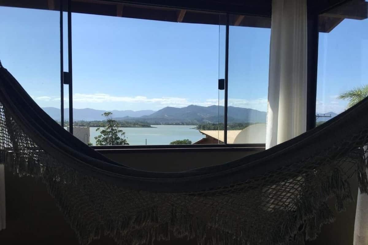 A hammock view of a lake with mountains in the distance.