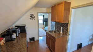 Una cocina con armarios de madera, encimera de granito y un lavabo.