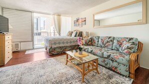 Une chambre à coucher comprenant un lit, un canapé, une commode en bois et un grand miroir.