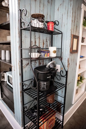 A kitchen shelf with various kitchen items including a coffee maker, tea pots, and containers. - The Loft on the Square (Highland)