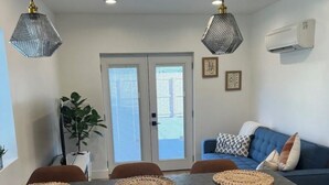 Una cucina moderna con un piano di lavoro in granito, mobili beige e un divano blu con cuscini decorati.