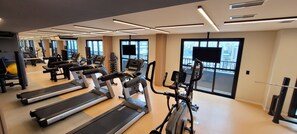 A gym with treadmills, exercise bikes, and weight machines.